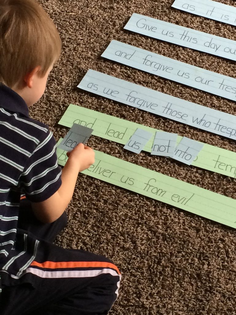 Boy placing word cards on printed sentences