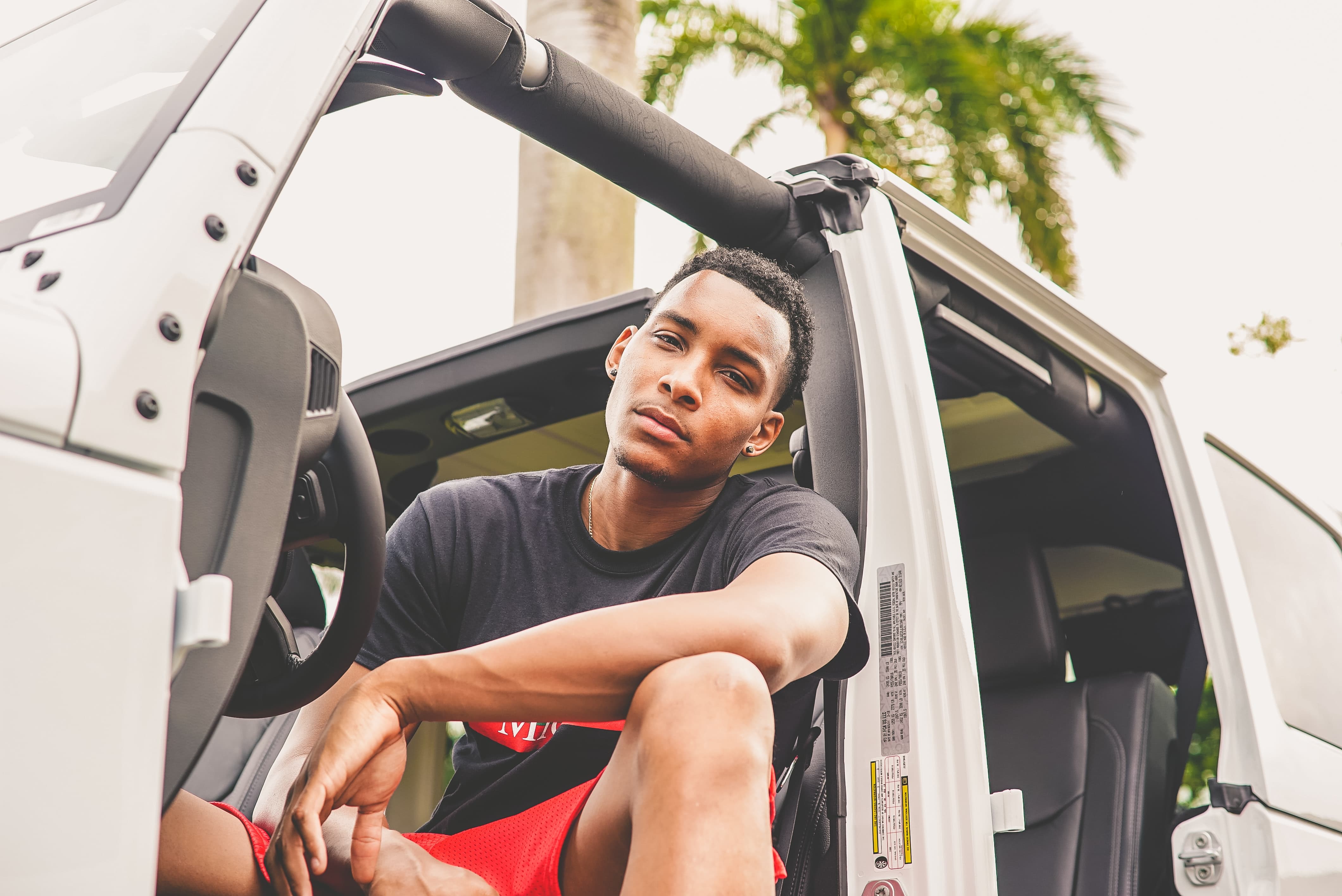 Black teenage boy sitting in the drivers seat of a car