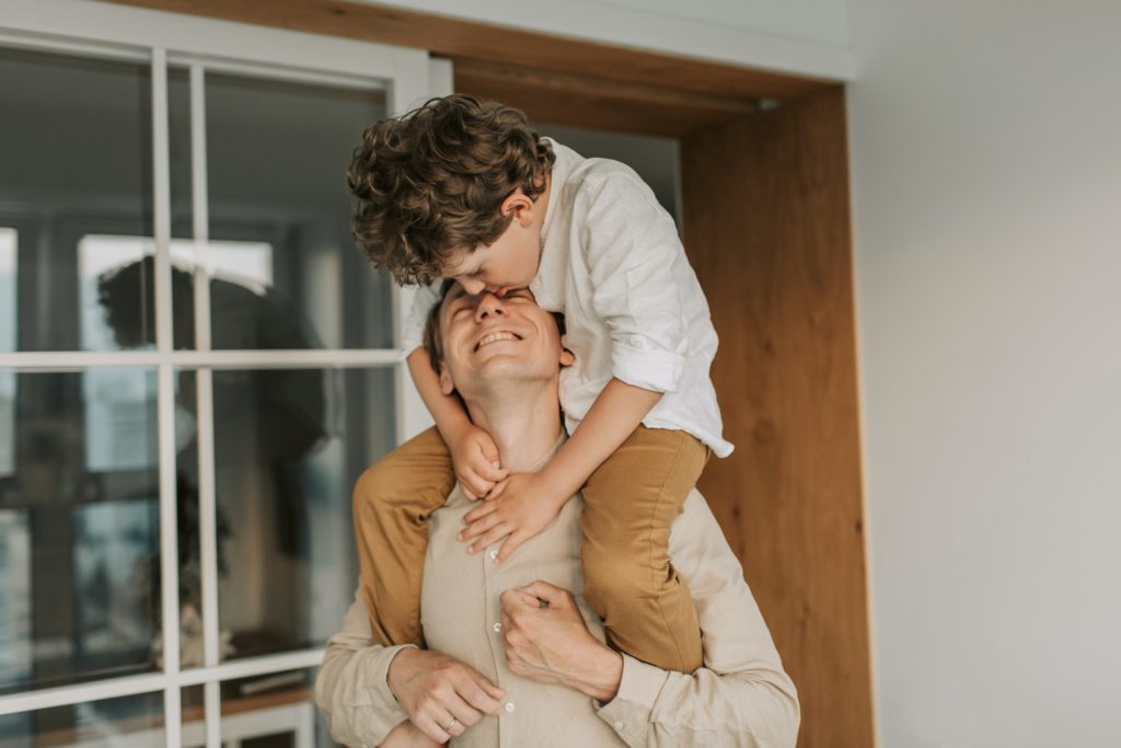 man carrying son on his shoulders