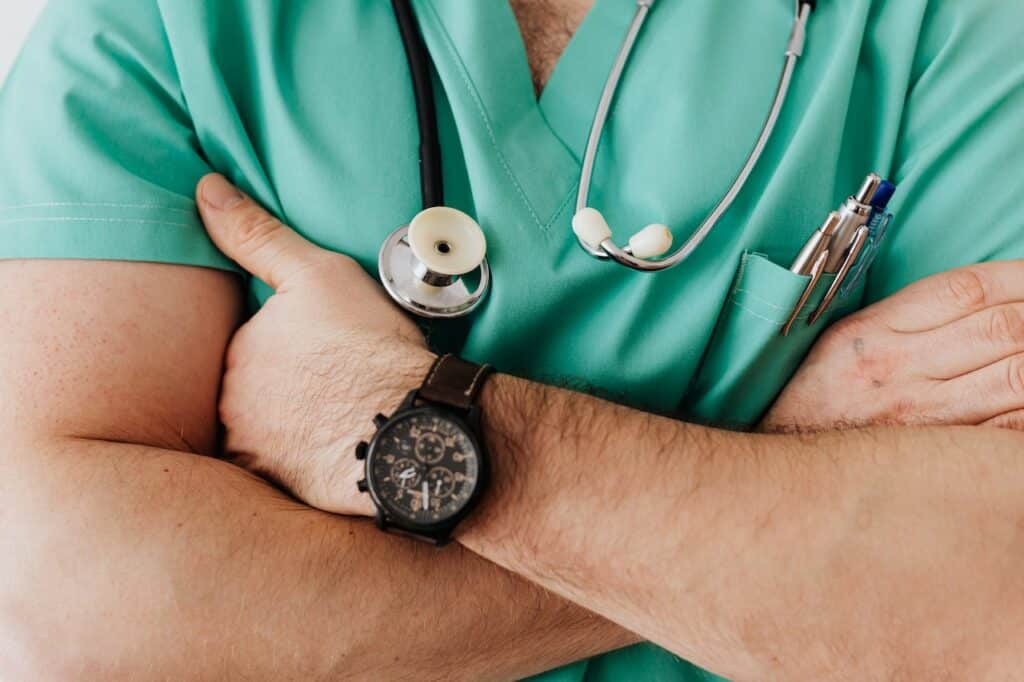 close up of crossed arms of unspecified healthcare provider wearing scrubs and a stethoscope